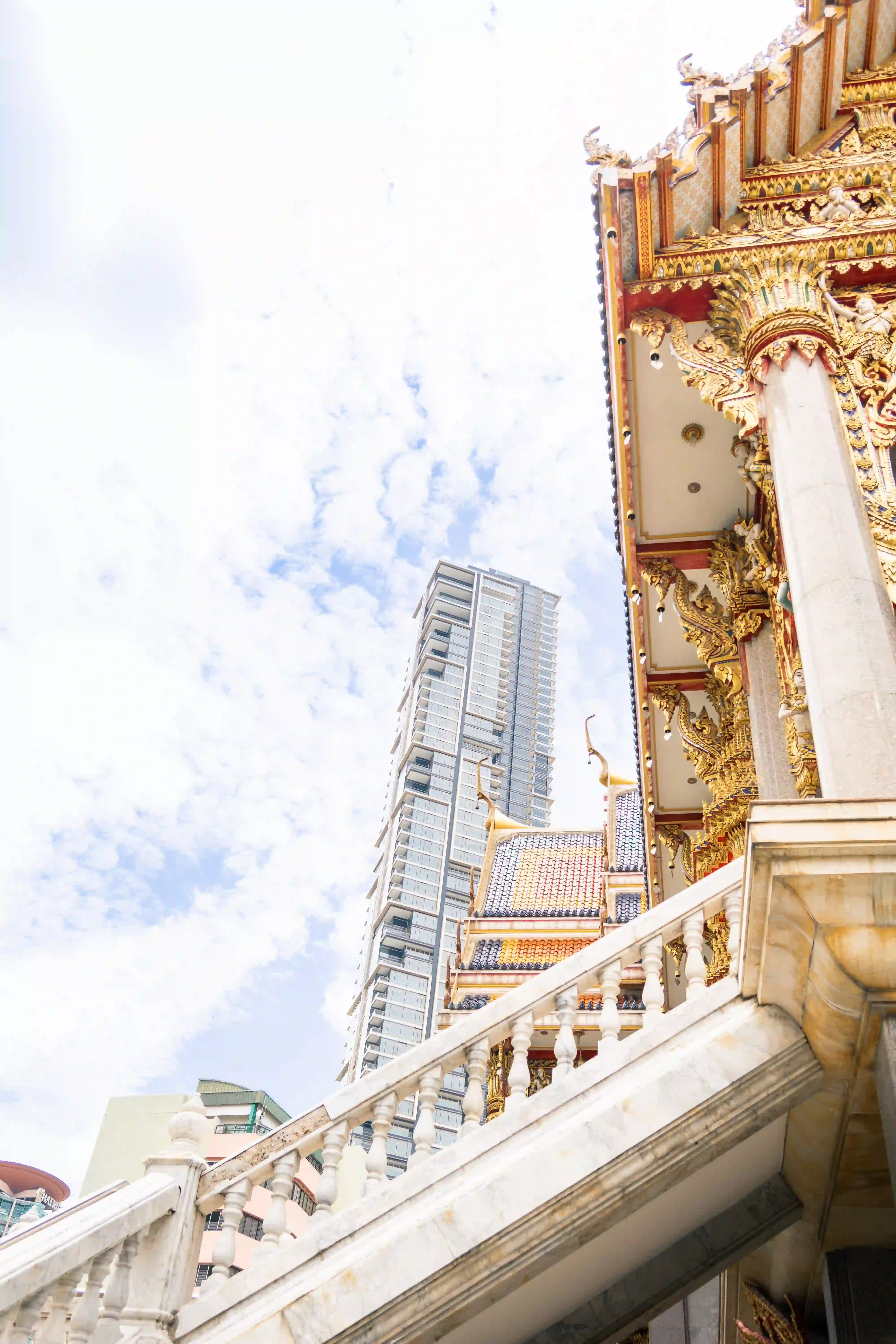 Balustrade and high-rise — old temple meets modern Bangkok